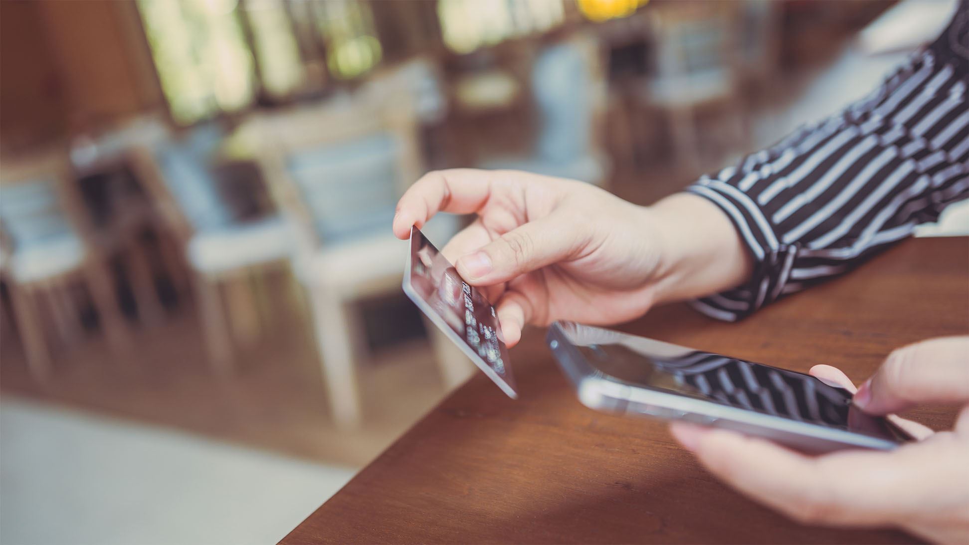 Woman Using Card with Phone