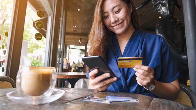 Woman Using Phone with Card